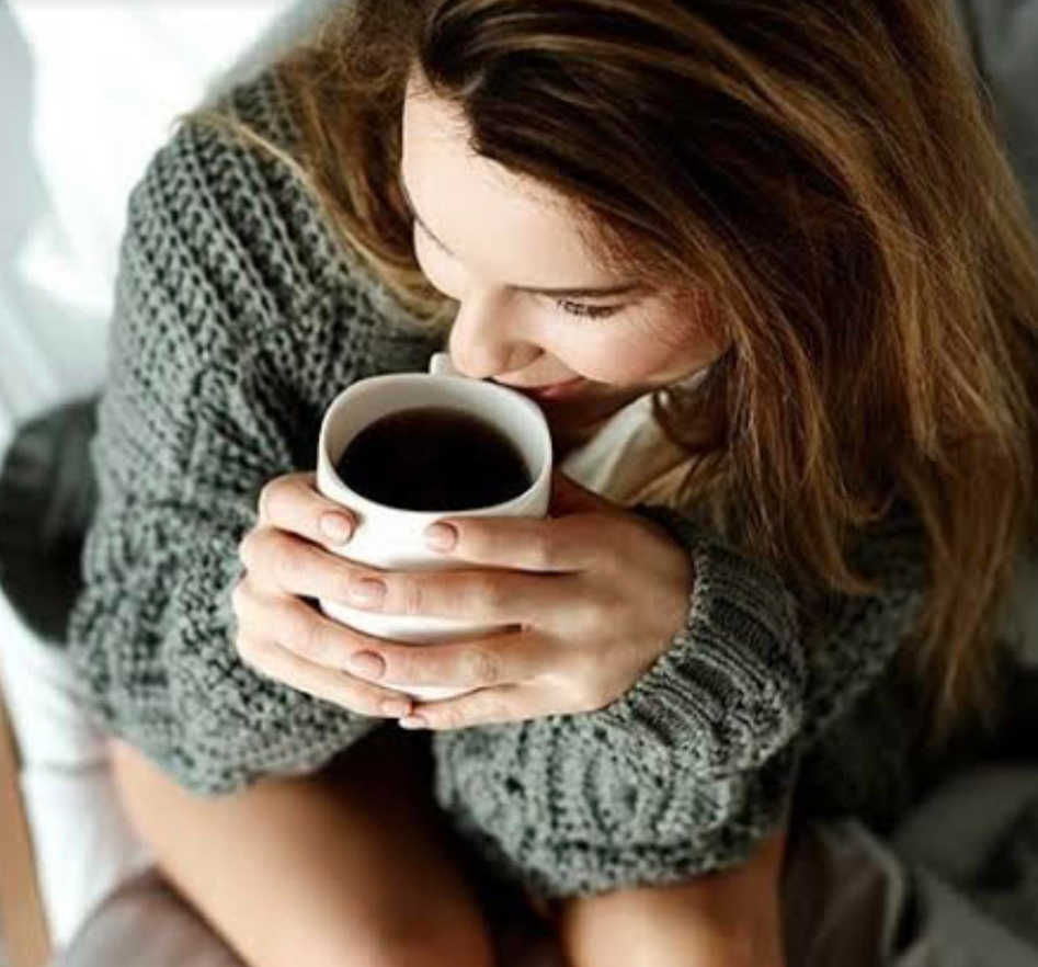 コーヒーを飲んでリラックスしている女性の写真